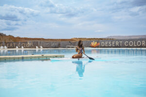 Woman paddleboarding in the lagoon at Desert Color Resort, showcasing lifestyle branding, outdoor resort fun, and Utah vacation activities