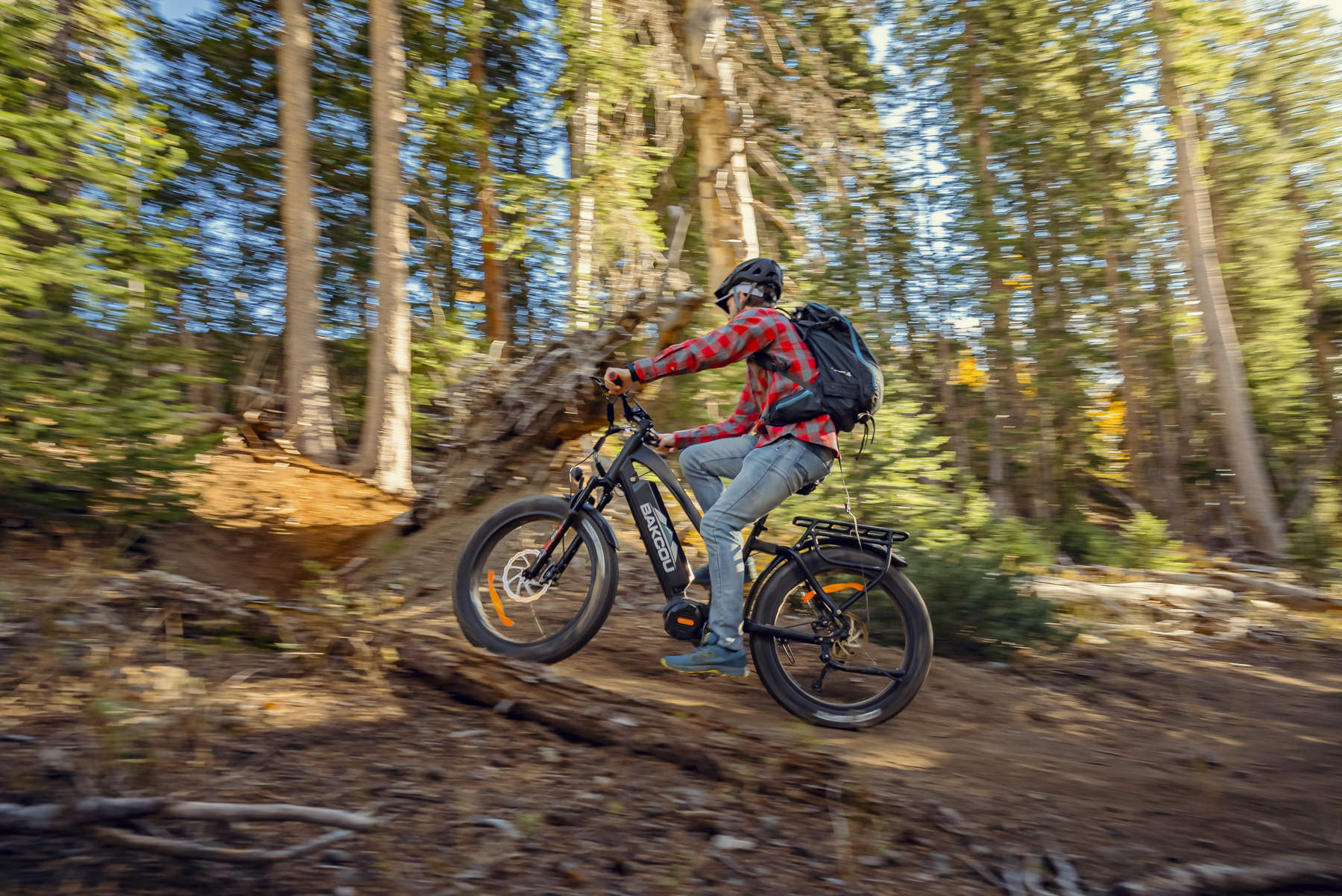 Mountain biker with motion blur riding electric bike through forest showcasing speed and adventure