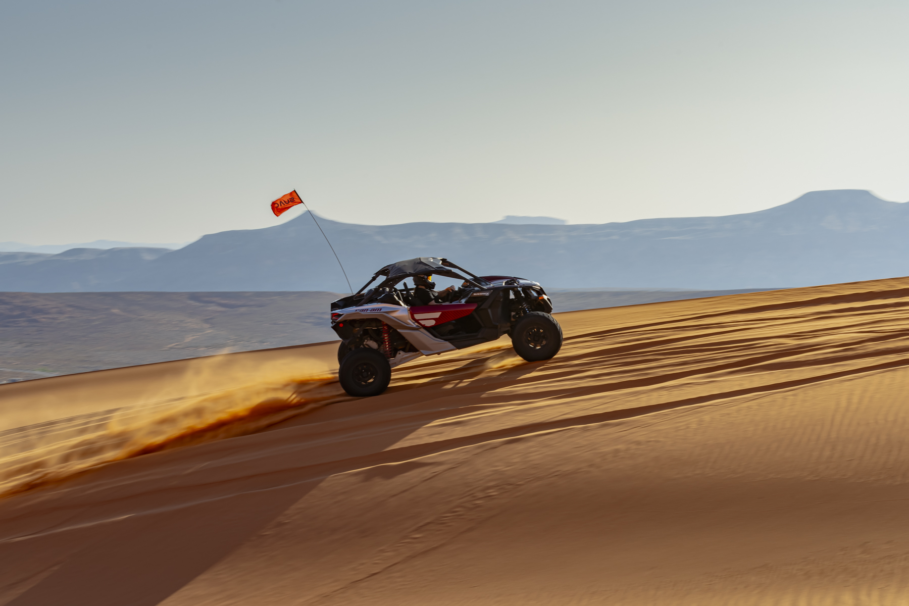 UTV climbs golden sand dunes near Sand Hollow Reservoir on a guided off-road adventure tour in Southern Utah