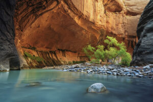 Lush greenery glows against canyon walls as still waters reflect soft light, crafted for commercial tourism branding and visual strategy in hospitality marketing.